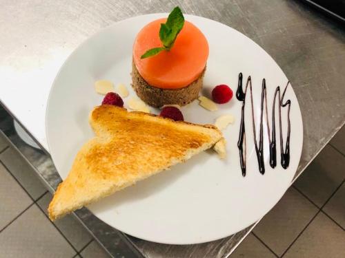 a white plate with an orange dessert and toast at Wellness hotel Rezidence in Nové Hrady