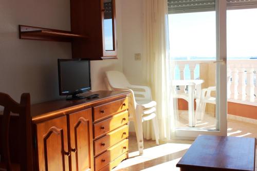 a kitchen with a dresser with a tv on top of it at Apartamentos Turísticos Hawaii 6 in La Manga del Mar Menor