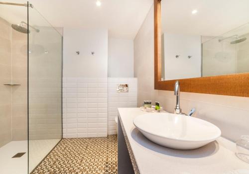 a white bathroom with a sink and a shower at Insotel Club Tarida Playa in Cala Tarida