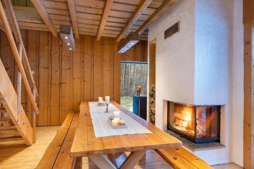 ein Wohnzimmer mit einem Kamin und einem Holztisch in der Unterkunft Haanjamehe Taluhotell in Haanja