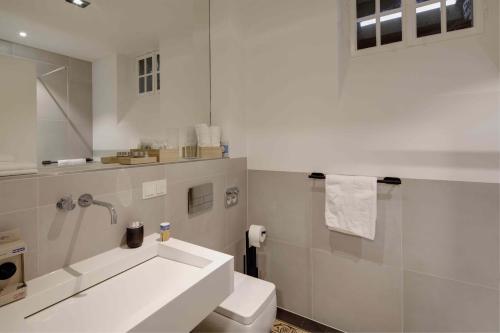 a white bathroom with a sink and a toilet at Boutique Apartments Freiburg - Eva in Freiburg im Breisgau