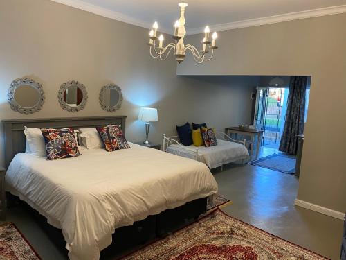Schlafzimmer mit einem Bett und einem Kronleuchter in der Unterkunft Steenkoppies semi self catering apartment in Magaliesburg