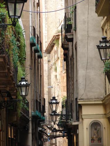a narrow alley with lights on the sides of buildings at Hostal Fina in Barcelona