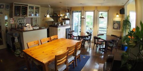 a dining room with a wooden table and chairs at Bellscabin Guesthouse in Karuizawa