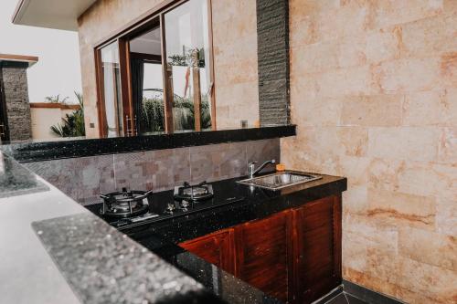 a kitchen with a sink and a counter top at AB UBUD LUXURY VILLA in Ubud