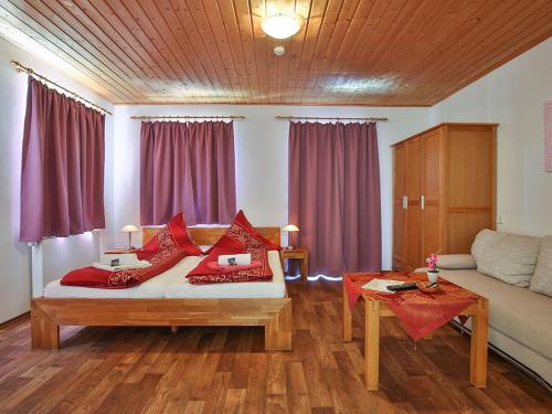 a room with a bed with red pillows on it at Claudi´s Radl Stadl in Kressbronn am Bodensee