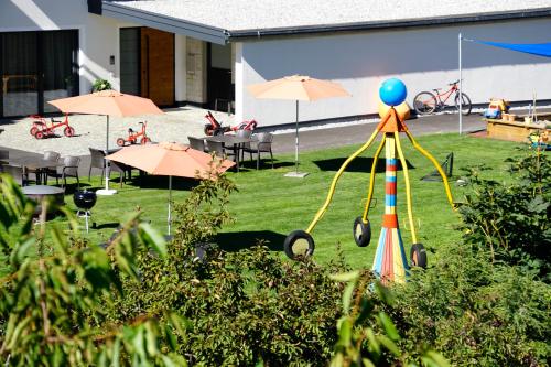 a garden with a playground with tables and umbrellas at Apart-Hotel Dreisonnenhof in Fiss