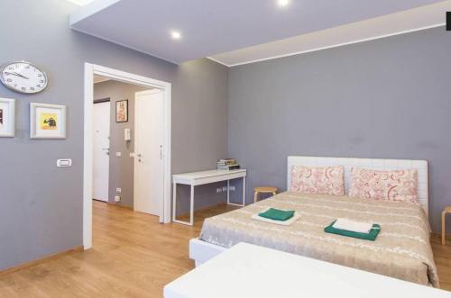 - une chambre avec un lit, une table et une horloge dans l'établissement GULLI SUITE LUXURY, à Milan