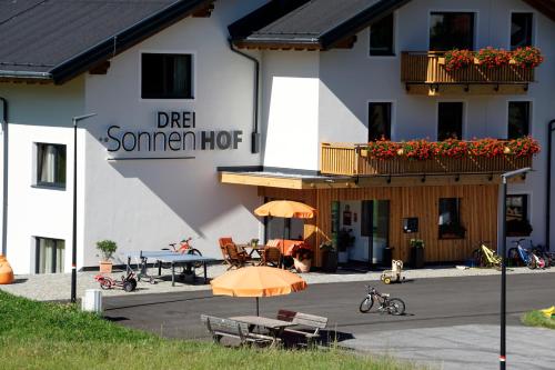 a building with tables and umbrellas in front of it at Apart-Hotel Dreisonnenhof in Fiss