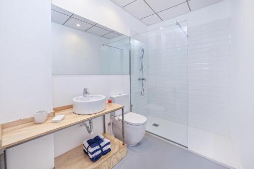 y baño blanco con lavabo y ducha. en Apartamentos Teatro Alicante, en Alicante