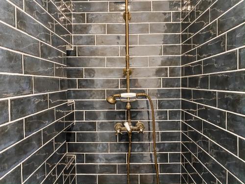 a black tiled wall with a gold towel rack at Vineyard and Views Exquisite Luxury Douro Villa with Sun-Drenched Infinity Pool in Folgosa