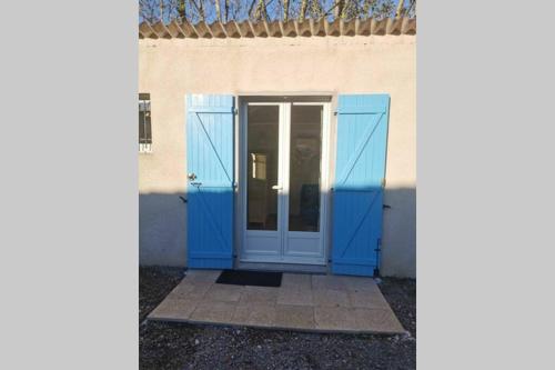 a blue door on a white building with at Studio indépendant au calme avec parking privatif in Caucalières