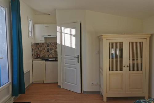a room with a door and a kitchen with a counter at Studio indépendant au calme avec parking privatif in Caucalières