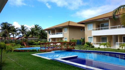 a resort with a swimming pool and a building at Residencial Verano 105C in Guarajuba