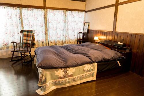 Schlafzimmer mit einem Bett, einem Schreibtisch und einem Stuhl in der Unterkunft CASA DE YOSHi 一棟貸し in Yamagata