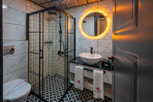 a bathroom with a sink and a shower and a toilet at White Corner Hotel in Istanbul