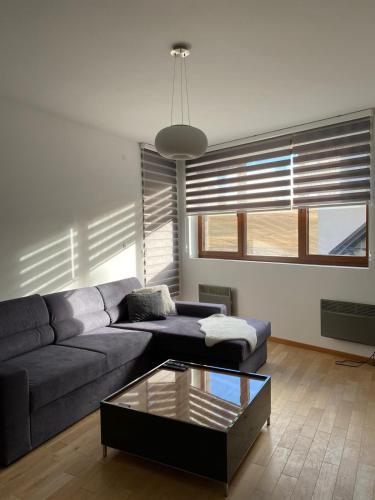uma sala de estar com um sofá e uma mesa de vidro em Apartmani Zlatiborio em Zlatibor