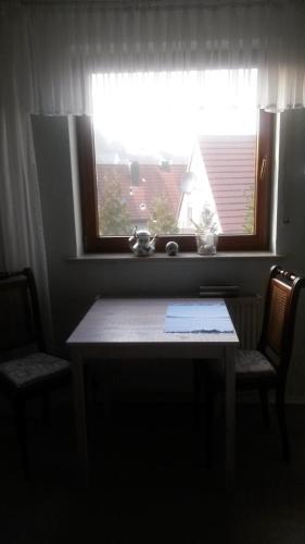 a table and two chairs in front of a window at Pension Eltmann in Eltmann