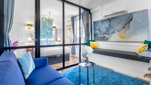 a living room with a blue couch and a bedroom at Luxury 2 Bedroom - Louvre & Champs Elysees in Paris