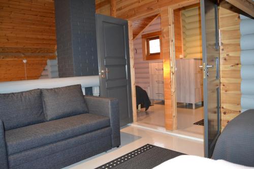 a living room with a couch and a glass door at Hallanpoika mökki in Hyrynsalmi
