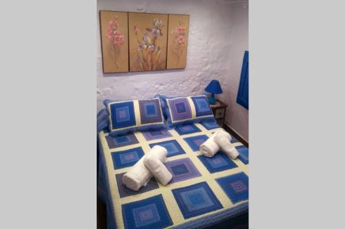a bedroom with a bed with blue and yellow at La casita Azul,apartamento encantador in Frigiliana