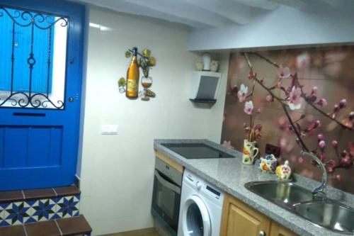 a kitchen with a sink and a washing machine at La casita Azul,apartamento encantador in Frigiliana