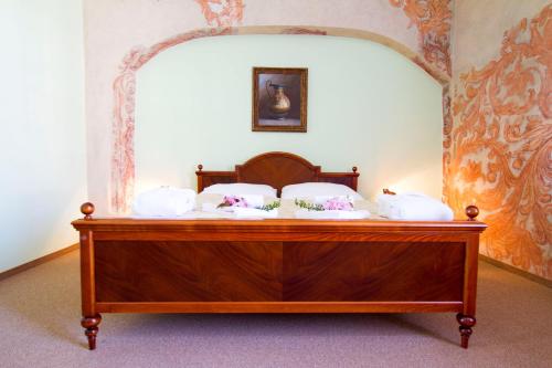 a bed with white pillows on top of it at Wellness hotel Rezidence in Nové Hrady