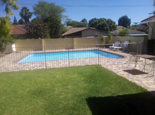 a fence around a swimming pool in a yard at 10 on Fairview B&B in Paarl