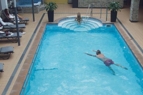 mężczyzna pływający w basenie w hotelu w obiekcie Wellness hotel Rezidence w mieście Nové Hrady