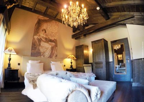 um quarto com uma cama grande e um lustre em Hotel Le Castel em Chamonix-Mont-Blanc
