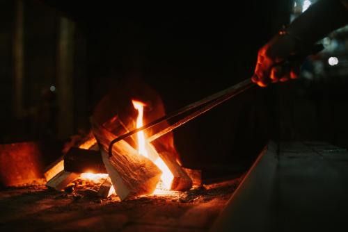 a person holding a knife over a fire at Vila Prezident in Sremski Karlovci