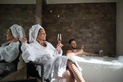 a group of people sitting in a tub with a glass of wine at Vila Prezident in Sremski Karlovci