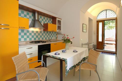 a kitchen with a table and chairs in a kitchen at Amalfi 51 con vista mare, giardino e terrazze in Conca dei Marini