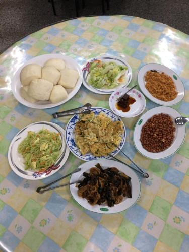 a table with plates of food on a table at Youlin Homestay in Meishan
