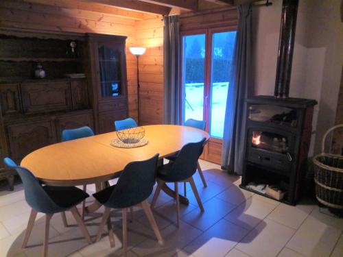 a dining room with a table and chairs and a stove at Chalet des Brocards in Saint-Maurice-sur-Moselle