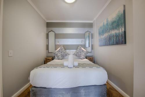 a bedroom with a large white bed in a room at Sea Front Granger Bay Apartment in Cape Town