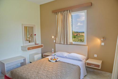 a hotel room with a bed and a window at Villa Melisti in Tsoukalades