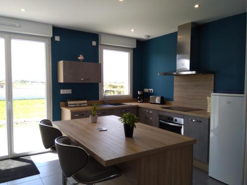 une cuisine avec une table en bois et des chaises. dans l'établissement Maison de vacances près de la mer à Créances, à Créances