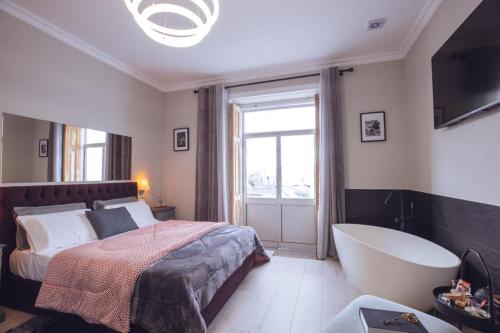 a bedroom with a bed and a bath tub at Downtown Loulé in Loulé