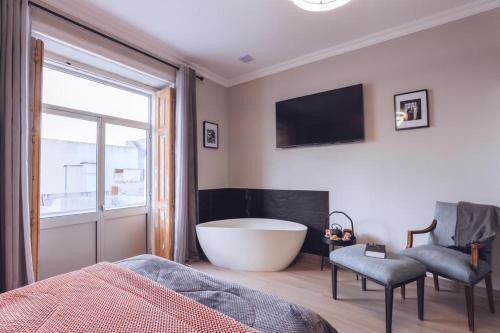 a bathroom with a bath tub and a tv at Downtown Loulé in Loulé