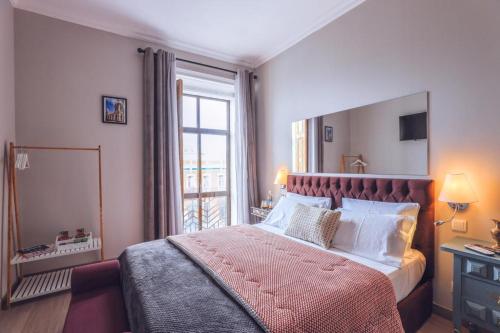 a bedroom with a large bed with a large window at Downtown Loulé in Loulé