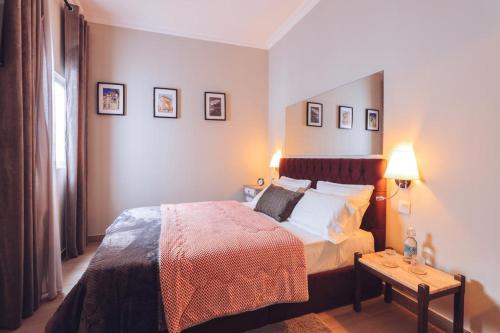 a bedroom with a bed and a table with two lamps at Downtown Loulé in Loulé