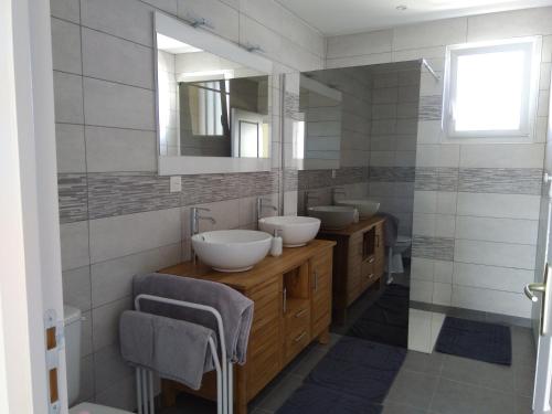 a bathroom with two sinks and a mirror at Maison de vacances près de la mer à Créances in Créances
