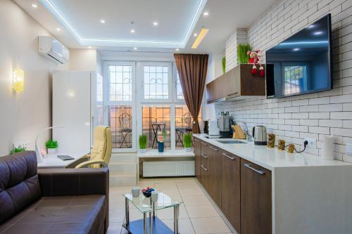 a kitchen and living room with a couch and a table at Big Jacuzzi , Sauna , Khreshchatyk apartments in Kyiv