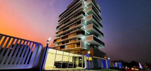 a tall building with a lit up facade at night at Number One Oxford Street Hotel & Suites in Accra