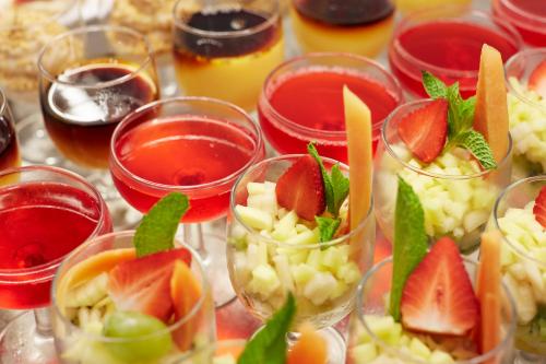 a table topped with glasses filled with fruit and juice at Insotel Club Tarida Playa in Cala Tarida