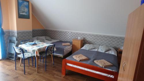 ブワディスワボボにあるWilla Marzenieのベッドルーム1室(ベッド2台、テーブル、椅子付)