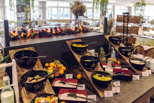 a buffet with bowls of food on a table at SEETELHOTEL Ostseehotel das Entdeckerhotel an der Ostsee und der perfekte Startpunkt für Ihre Inselabenteuer in Ahlbeck