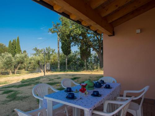a white table with white chairs and a blue table cloth at Holiday Home La Rocchetta by Interhome in Montescudaio