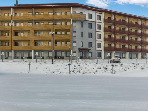 a building in the snow in front of a parking lot at Holiday Home Ylläs chalets 2101 by Interhome in Ylläsjärvi